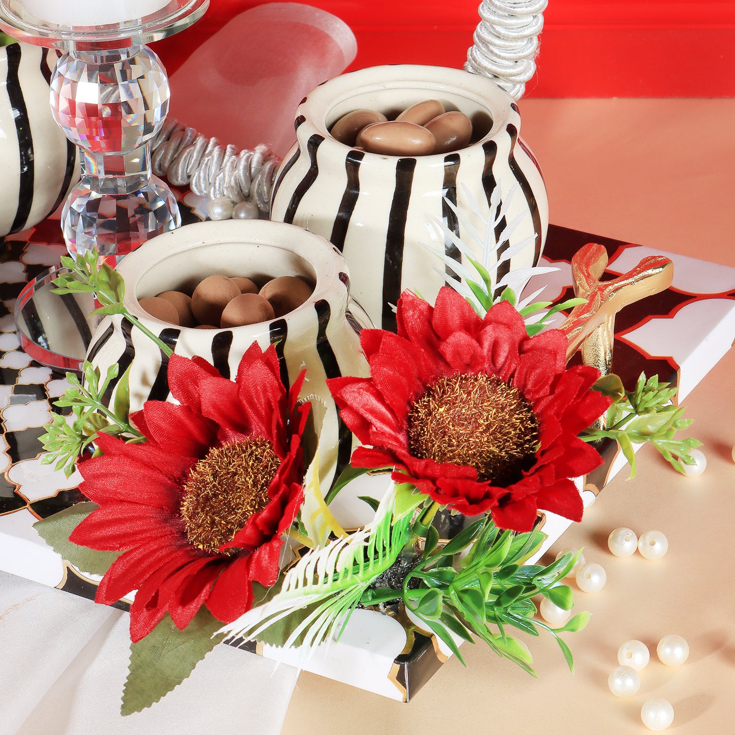 This gifting tray comes with 1 glass candle holder adorned with red flowers & 4 ceramic abstract print jars filled with Oreo almonds , chocolate raisins, Pista flavored Cashew and Munchy masala cashew decorated in our MDF tray.