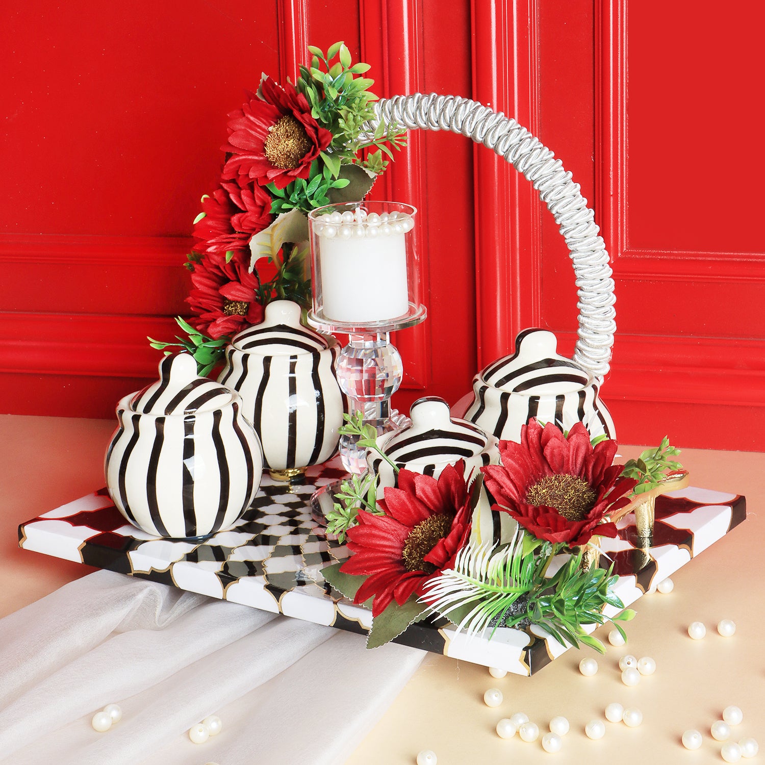This gifting tray comes with 1 glass candle holder adorned with red flowers &amp; 4 ceramic abstract print jars filled with Oreo almonds , chocolate raisins, Pista flavored Cashew and Munchy masala cashew decorated in our MDF tray.